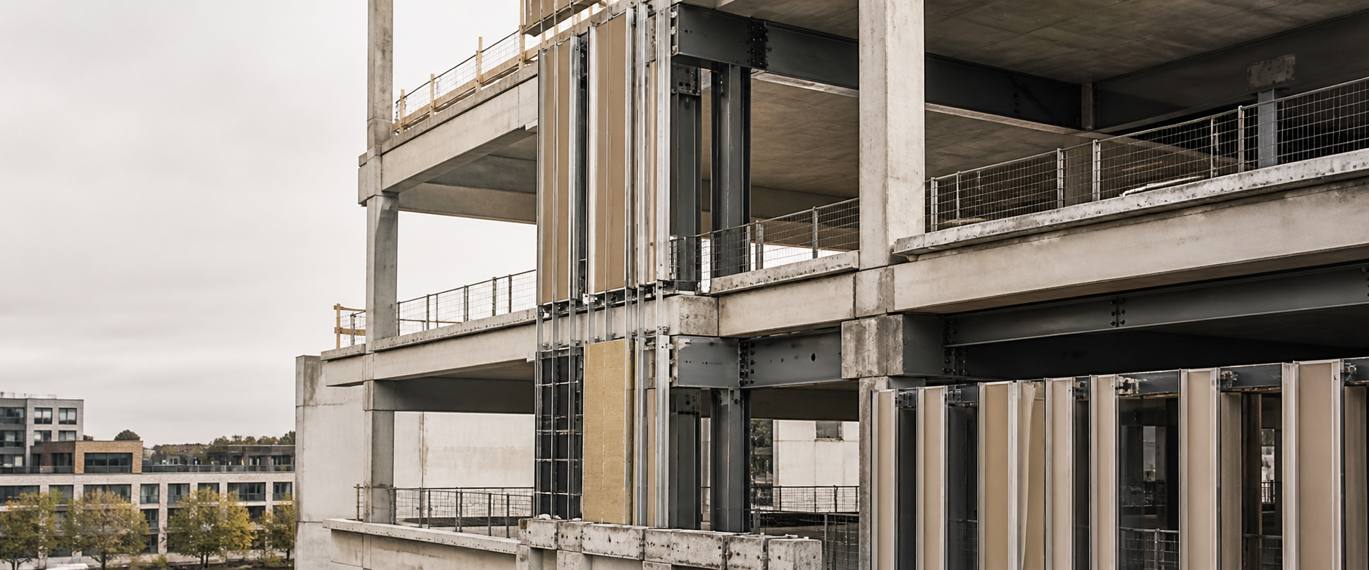 Exposed concrete and steel structural frame during façade construction